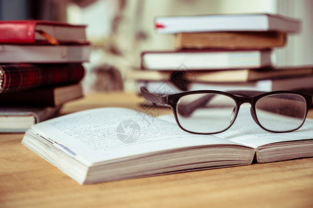 在木桌 软焦点 旧音上 贴近有眼镜的开放书文学知识智慧学习图书馆学生故事数据桌子学校背景图片