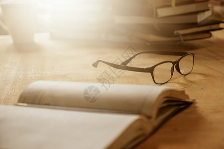 柳林风声眼镜贴近 书放在木桌 有选择的焦点 明亮的太阳光和风声上背景