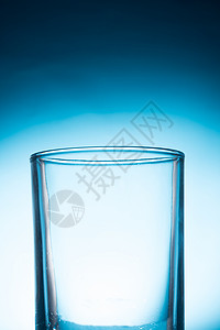 蓝色背景上的空玻璃杯饮料液体不倒翁空白白色玻璃脆弱性器皿杯子水晶背景图片