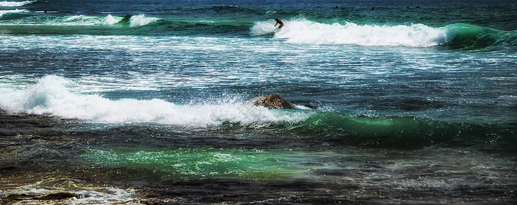 太阳光灯冲浪者乘着浮板蓝海水随心所欲行动运动冒险蓝色史诗热带木板旅行冲浪假期背景图片