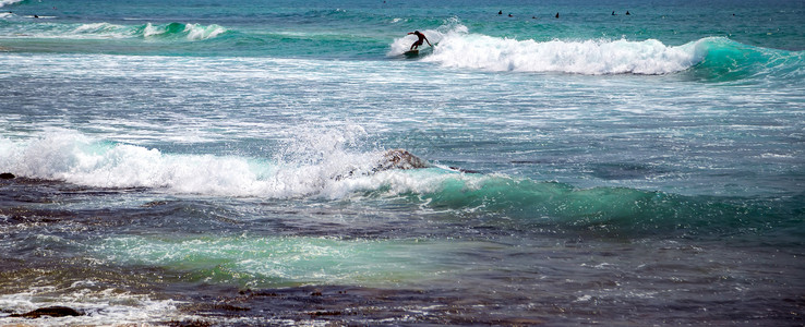 太阳光灯冲浪者乘着浮板蓝海水随心所欲冲浪海滩史诗男人假期运动海浪海洋设施天线背景图片