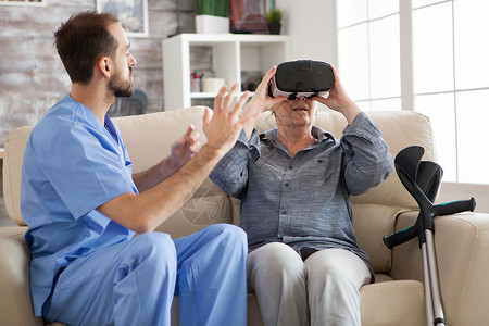 020使用虚拟现实眼镜的年长妇女疗养院沙发老年疾病成人药品头发拐杖女性虚拟现实背景