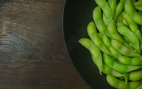 在煮沸前毛豆Edamame在黑色板块上显示食物含量的最高视图图像美食营养毛豆大豆桌子豆类蔬菜饮食绿色小吃背景