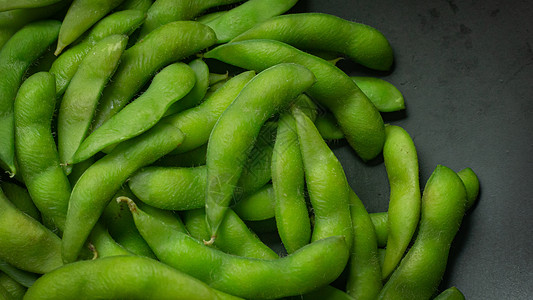 在煮沸前毛豆Edamame在黑色板块上显示食物含量的最高视图图像饮食绿色美食毛豆大豆桌子豆类小吃营养蔬菜背景