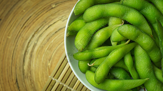 在煮沸前毛豆Edamame在白碗中展示食物内容的顶端视图图像美食豆类小吃营养蔬菜毛豆绿色桌子大豆饮食背景