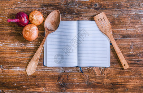 木制桌顶上有洋葱的烹饪书背景图片