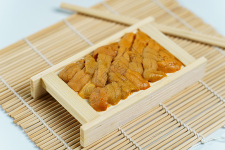 日本的海胆在木盘 寿司和生鱼苗中鱼片烹饪宏观大学寿司店橙子海鲜食谱盘子美食背景图片