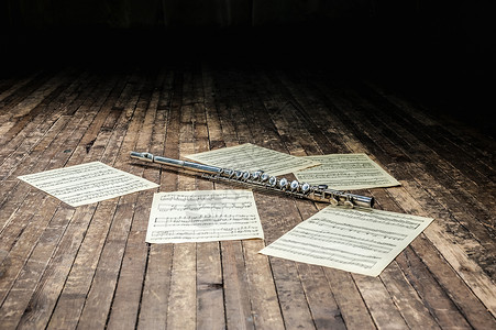 笛子在木制舞台上 在带音符的乐谱中背景图片