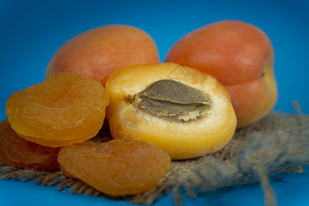 干燥的杏子 新鲜的整顿和半分一半的杏子甜点水果团体桌子乡村食物健康种子饮食麻布背景图片