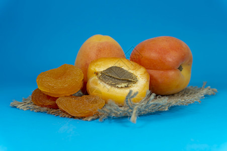 干燥的杏子 新鲜的整顿和半分一半的杏子麻布甜点营养桌子农业水果果汁种子正方形团体背景图片
