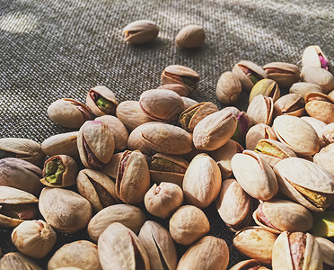 生锈亚麻布背景的Pistachio坚果小吃食物棕色植物盐渍开心果乡村基础种子营养背景图片