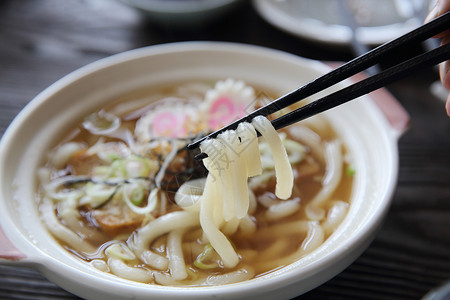 日本食品乌冬面拉面筷子煮沸食物豆腐韭葱桌子蔬菜盘子店铺面条背景图片