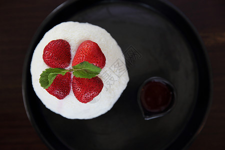 日本甜点用牛奶和草莓制成的碎冰杯子勺子锥体糖浆水果海滩小吃味道刮胡子奶油背景
