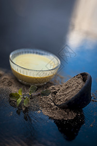 Ayurvedic 草药brahmi或Wathhyssop及其有益的糊状玻璃碗和木质表面的粉末水果温泉植物面具头发皮肤化妆品草本背景图片