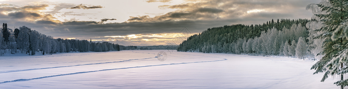 冬季森林在两侧和中间结冰的河流上的日落全景 瑞典北部典型的风景 — 白霜覆盖的桦树和云杉 — 非常寒冷的一天 瑞典拉普兰背景图片