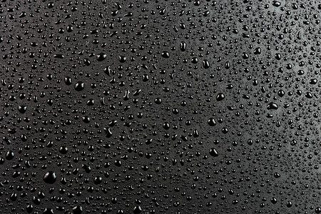 抽象平面黑色疏水表面宏观背景上的水滴工业张力灰色技术空白墙纸高科技坡度材料背景