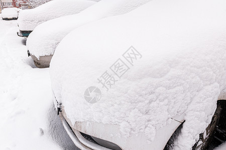 白雪皑皑的汽车在白天停车时经常遭受暴风雪-广角图片高清图片