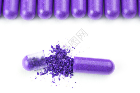质子重离子治疗白色背景上分离的一排质子紫色有机胶囊 特写一个打开药品宏观药店植物制药饮食药片食物团体药物背景