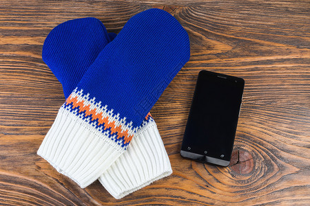 木本底带手机的蓝色和白色编织手套天气黑色季节空白衣服羊毛小样配饰背景图片