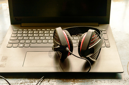 双耳降噪便携式耳罩式双耳 USB 耳机 带麦克风降噪和超声波音量调节耳机 适用于计算机 Skype 在早晨阳光下放在笔记本电脑上 音乐背背景