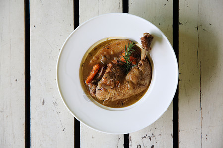 Coq au vin 鸡肉烤红酒加胡萝卜和土豆美食家禽胸部国家盘子厨房洋葱沙锅午餐蔬菜背景图片
