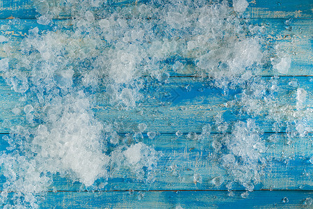 陈年蓝色木制桌子上的碎冰块冻结冷藏立方体积木冷却器工作室剪裁水晶宏观正方形背景图片