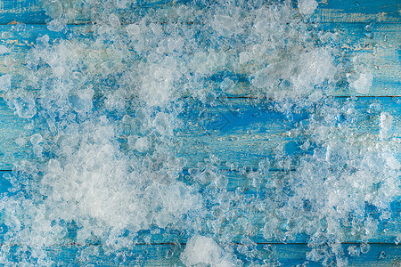 陈年蓝色木制桌子上的碎冰块宏观冻结小路玻璃积木气泡剪裁立方体正方形水晶背景图片