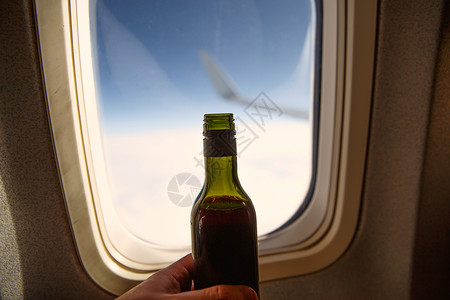 在门洞对面一瓶酒 飞机上酒精味的瓶子嘲笑托盘天空运输拉子航班木头产品商业奢华背景图片