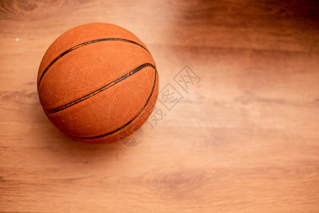 篮球对着硬木地板 从上面拍摄背景图片