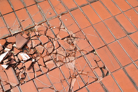 当心重物坠落破碎的瓷砖地板 与重物撞击而损坏的瓷砖地板背景