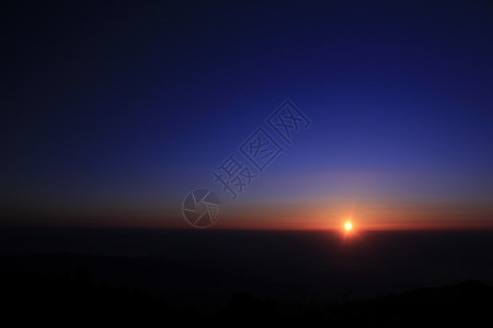 日出在山顶的清晨山峰上马戏团蓝色辉光图层远景戏剧性天空紫色天气构图背景图片