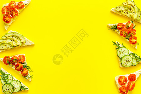 黄色厨房餐桌顶视图空间的鳄梨三明治边框 复制空间早餐盘子午餐蔬菜维生素小吃食物面包背景图片