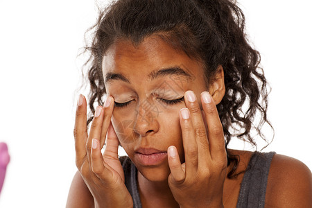 深色皮肤女性在眼皮上涂一个化妆底背景图片