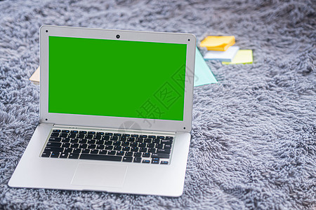 灰地毯上绿色屏幕的顶顶膝盖电脑照片商业办公室工作技术绿屏记事本白色桌子职场背景图片
