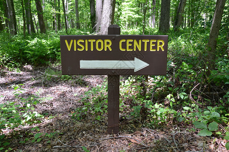 林中带白箭的木材访客中心标志背景图片