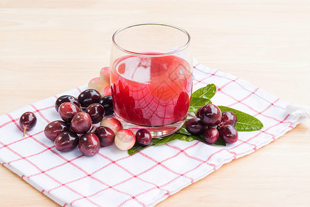 樱桃蔓越莓果汁新鲜的加里萨卡兰达果汁杯 与加里萨卡兰达frui热带植物浆果饮食叶子草本植物食物背景