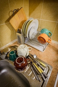 厨房的洗碗和餐具烘干架子白色金属杯子勺子玻璃盘子制品背景图片