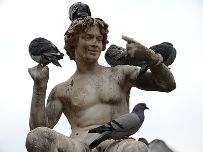一个男孩的雕像 和一些鸽子围起来背景图片
