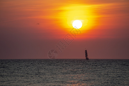 在日落的生动时刻在斯赫维宁根港荷兰海牙内行进和准备入口处 荷兰海牙海洋天空橙子太阳支撑热带海岸地平线反射海浪背景图片