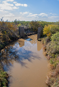 非常泥土的河流和被摧毁的德克萨斯旧桥底背景图片