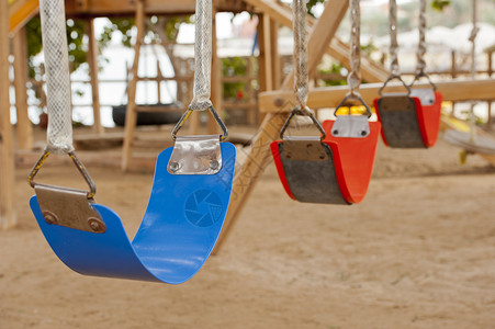 儿童游戏区的摇摆乐趣玩具橙子公园娱乐蓝色塑料框架游乐操场背景图片