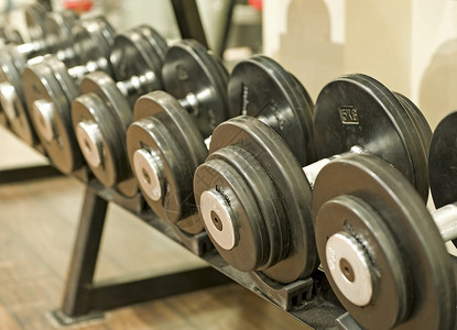 健身房的哑巴人体重哑铃架子体育俱乐部活动运动举重中心健身背景图片