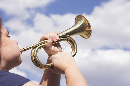 女人吹号角金属音乐黄铜音乐家女孩小号女性管子蓝色乐器背景图片