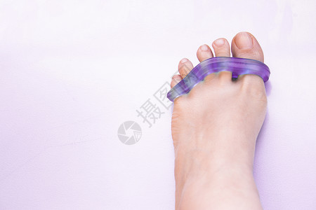 脚趾外翻用硅酮假肢将脚趾分开的女人的脚沙龙指甲药品女性状况解剖学医疗白色畸形修脚背景