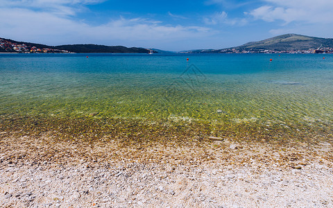 大洋彼岸水下的石头 海滩上的海卵石 在 th 的海卵石假期旅行支撑岩石海浪海岸线墙纸海洋巨石蓝色背景