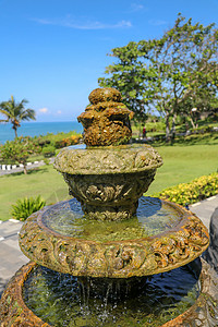 巴厘语与喷泉的和平风景 在印度教寺庙海神庙附近的公园 巴厘岛 印度尼西亚 用于景观设计的热带花园中的小型装饰喷泉 流水的石头三级喷泉旅背景