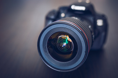 紧凑型反射镜数字照相机或DSLR 带镜头镜头和透镜反射镜焦点视频照片玻璃乐器光圈摄影机摄像师电影耀斑背景