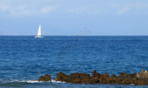 帆船白色游艇桅杆岩石天空地平线港口海洋背景图片