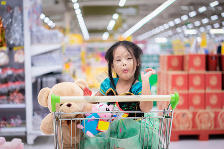 穿着公主服装的亚洲小女孩 坐着洋娃娃坐在那里扮演顾客戏服零售大卖场娃娃玩具购物孩子大车部门高清图片素材