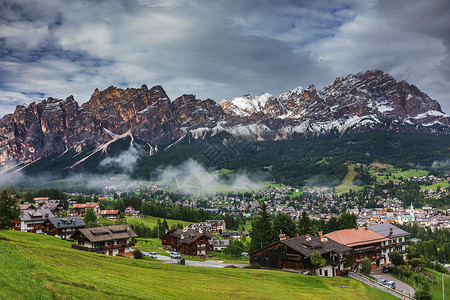 与高山绿色林冠的全景图景Cortina dAmpezzo镇正方形旅游山峰天空教会村庄景观城市阳光首脑背景图片